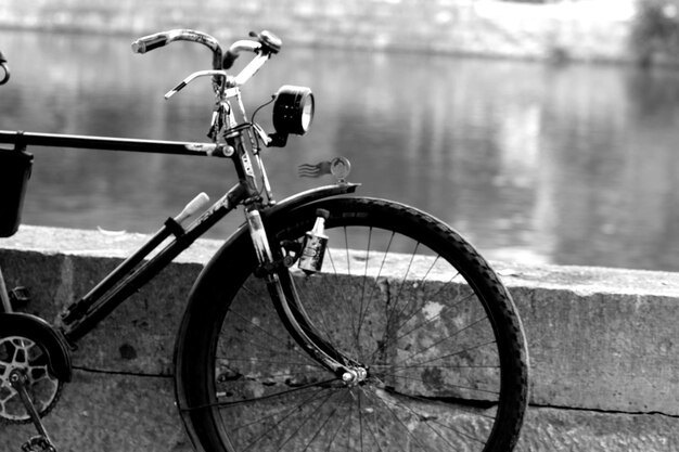 Foto bicicleta estacionada por um corrimão contra o lago