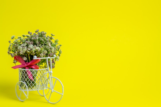 Una bicicleta de juguete lleva flores.