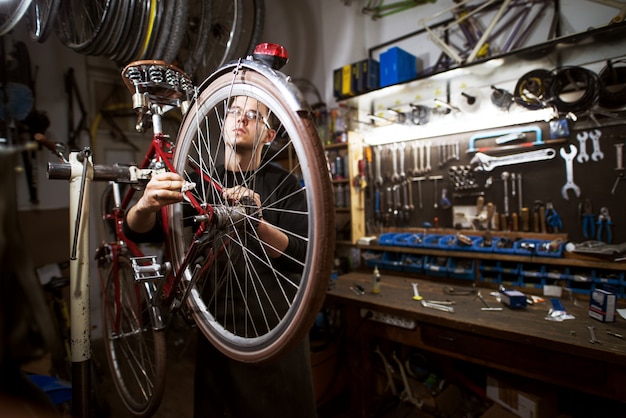 Bicicleta de limpieza profesional joven en el taller.