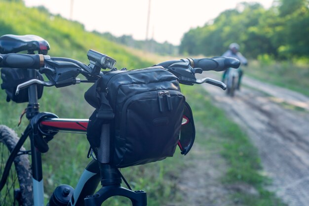 Bicicleta de montaña con una bolsa en el manillar en el fondo de los motociclistas.