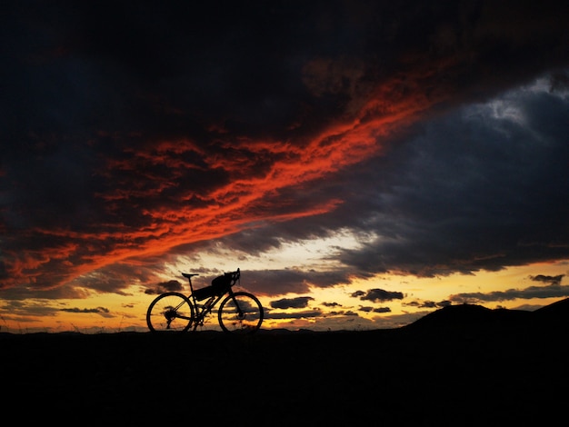 Foto bicicleta en la montaña en una hermosa puesta de sol