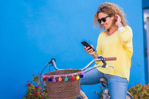 Foto bicicleta mulher encantadora na cidade se sente serena e relaxada enquanto olha para o telefone com um olhar bonito transporte ecológico para reduzir a pegada de carbono de mulheres em bicicleta