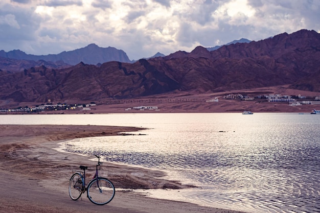 Bicicleta en la playa de la puesta del sol, Dahab, Egipto