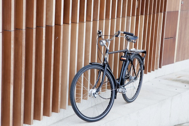 Bicicleta preta apoiada em uma parede moderna