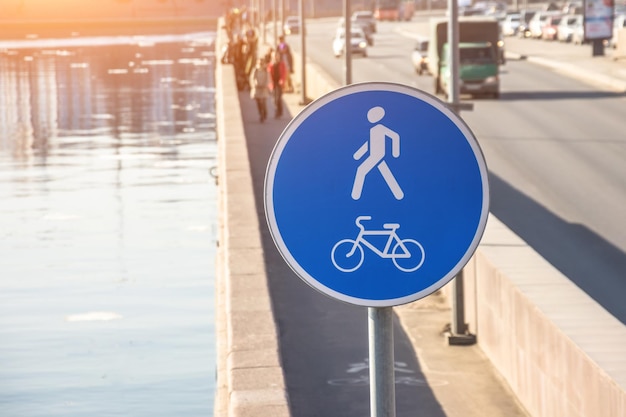 Bicicleta redonda azul y camino peatonal en el terraplén del río.