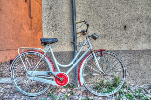 Bicicleta roja y blanca contra la pared Procesada para efecto de mapeo de tonos hdr