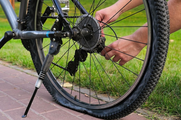 Una bicicleta con una rueda trasera plana estacionada en una carretera de la ciudad