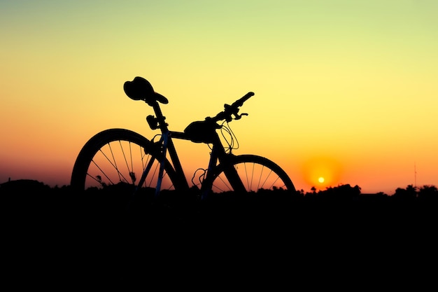 Bicicleta silhueta em fundo por do sol.