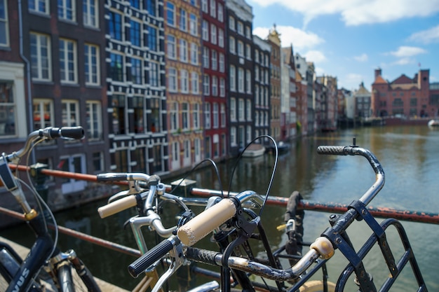 Foto bicicleta sobre canal borroso de amsterdam, tono cálido vintage