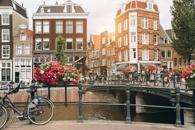 Bicicleta velha na ponte em Amsterdã Holanda contra um canal durante o dia ensolarado de verão Vista icônica de cartão postal Conceito de turismo