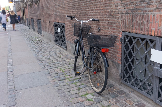 Bicicleta velha perto da parede de tijolos, Copenhague, Dinamarca