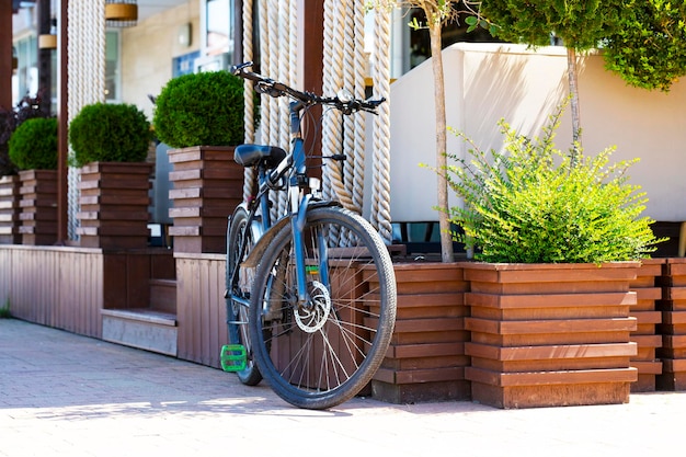 Bicicleta verde estacionada cerca de la cafetería con espacio de copia de pared roja