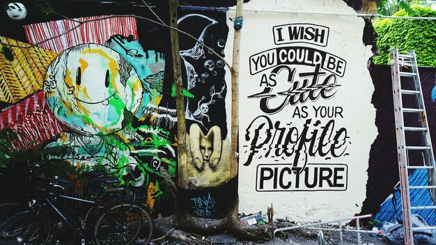 Foto bicicletas estacionadas contra el graffiti en la pared