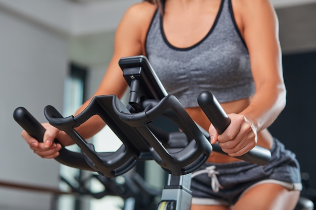 Bicicletas estáticas fitness girl en un club deportivo de gimnasio