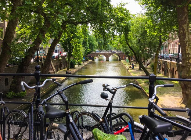 Bicicletas de pie en el puente con una vista increíble sobre el antiguo canal y las calles de utrecht holanda ...