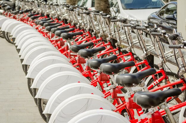 Bicicletas vermelhas estacionadas em uma fila na rua, em barcelona, espanha