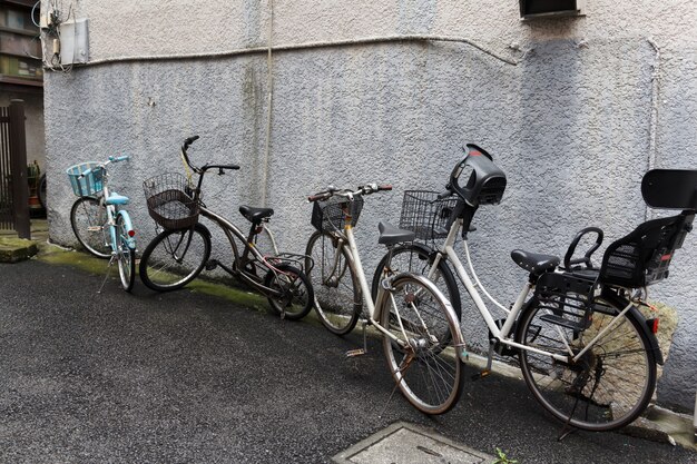 Bicicletas viejas contra una pared exterior de la casa.