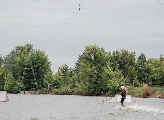 Bielawa, Polen. 06.03.2020 Wawa Wake. Junge Sportlerin gleitet auf Wasserskiern auf den Wellen auf dem See. Mädchen reitet auf Wakeboarden