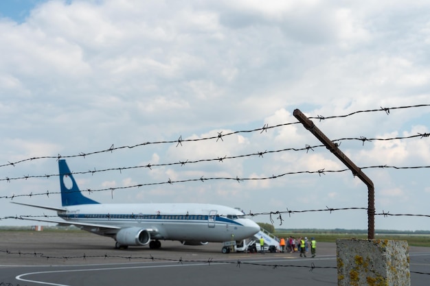 Bielorrusia Minsk 3 de julio de 2021 Un avión en el territorio del aeropuerto contra el fondo de alambre de púas Territorio cerrado de un aeródromo privado Aterrizaje de emergencia del avión