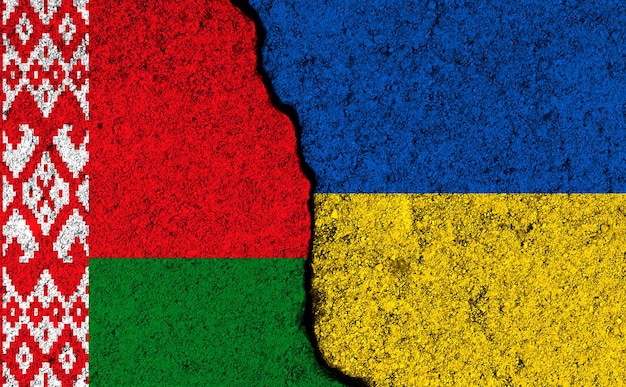 Bielorrusia y Ucrania banderas juntas pintadas en una pared de hormigón agrietada foto de fondo