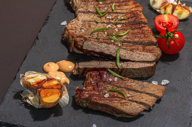 Bien hecho bistec de ternera asada con salsa de romero y ajo a la parrilla una luz dura de moda