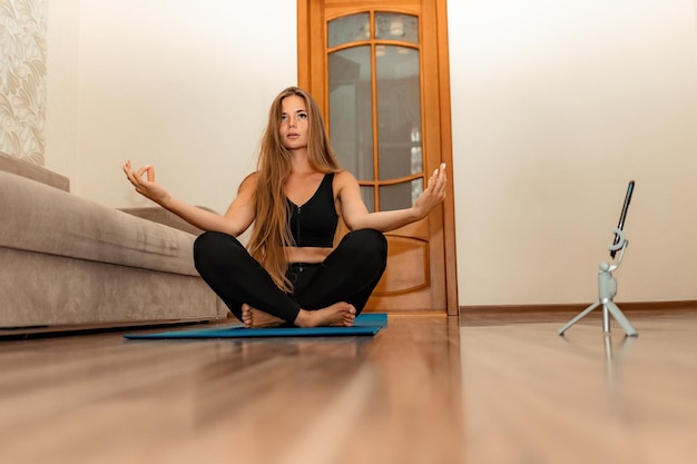 Bien parecido mujer de mediana edad con instructor de fitness de pelo largo en ropa deportiva negra haciendo