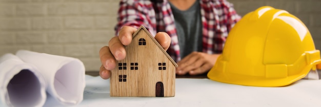 Bienes raíces, ingeniero muestran concepto de casa pequeña, arquitecto y constructor