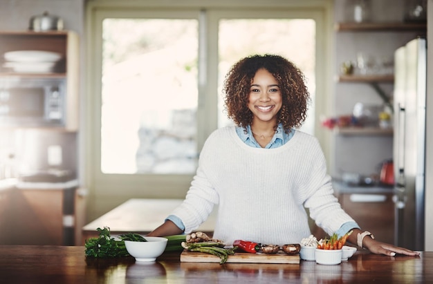 Bienestar de la salud y comida de un estilo de vida saludable Retrato de una mujer negra feliz cocinando en una cocina Nutricionista afroamericana haciendo una comida sana y equilibrada con superalimentos orgánicos en casa