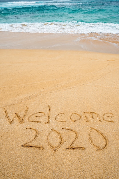 Bienvenido 2020 escrito en la arena