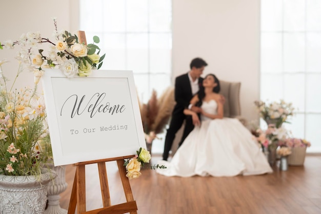 Foto bienvenido al cartel de la boda con la novia y el novio en el fondo