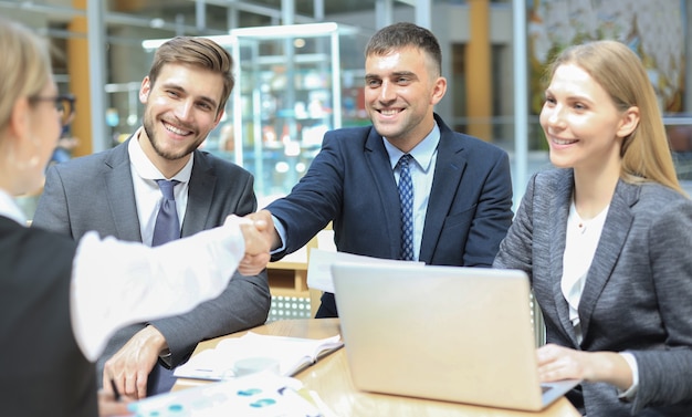 Bienvenidos a nuestro equipo. Jóvenes empresarios modernos estrecharme la mano mientras trabajaba en la oficina creativa.