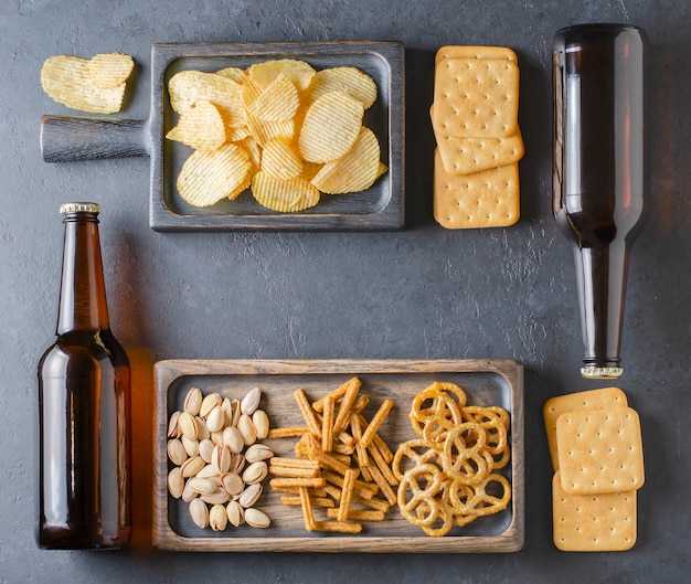 Bier in dunklen Glasflaschen und salzigen Snacks