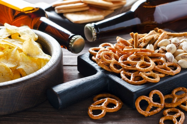 Bier in Glasflaschen und salzige Snacks für Bier.