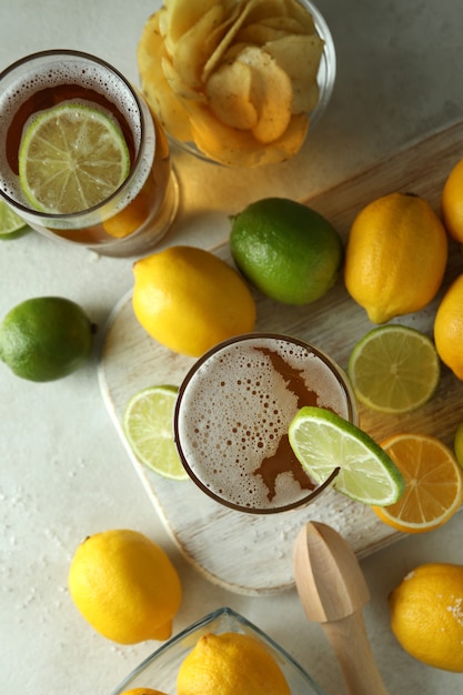 Bier mit Zitrusfrüchten auf weiß strukturiertem Tisch