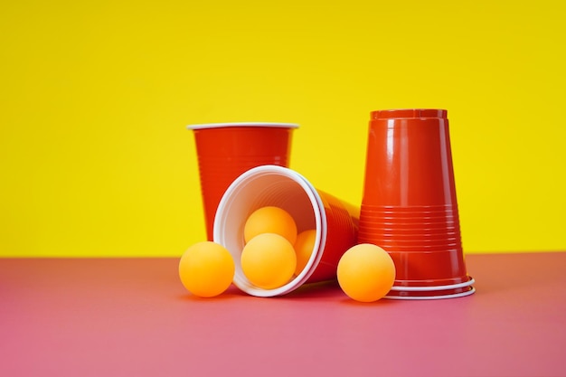 Bier-Pong-Spiel mit roten Tassen auf gelbem Hintergrund