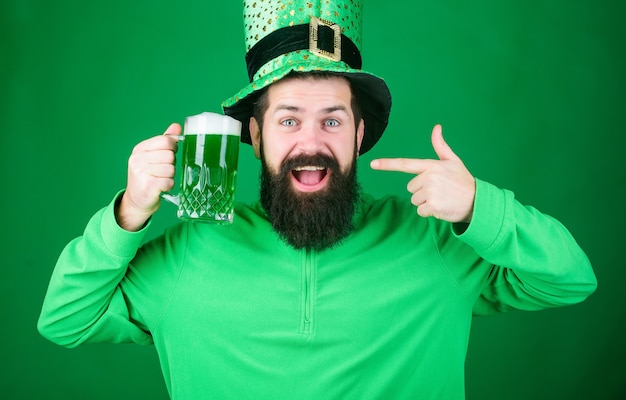 Foto bier trinken feiern. fest- und feiertagsmenü. gefärbtes grünes traditionelles bier. patricks day-party. alkoholisches getränk. symbol von irland. mann bärtiger hipster trinken bier. irischer pub. sehr empfehlenswert.