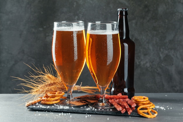 Bier und appetitliche Biersnacks eingestellt. Tisch mit Krug Bier, Holzbrett mit Würstchen