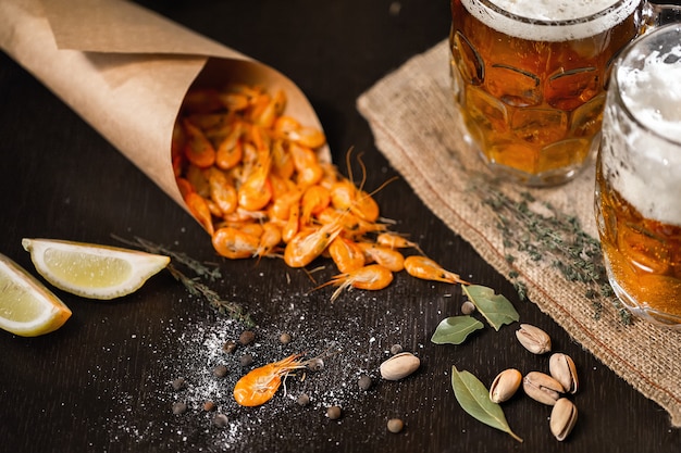 Bier und gegrillte Garnelen auf Holztisch