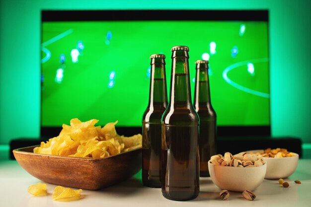 Bier und Snacks auf Fußballspiel-TV-Hintergrund