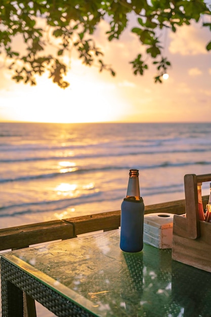 Bierflasche auf dem Tisch mit wunderschönem Blick auf den Sonnenuntergang auf koh chang trat thailandDie Insel Ko Chang, die auch als "Elephant Island" bekannt ist, wurde wegen ihrer elefantenförmigen Landzunge benannt