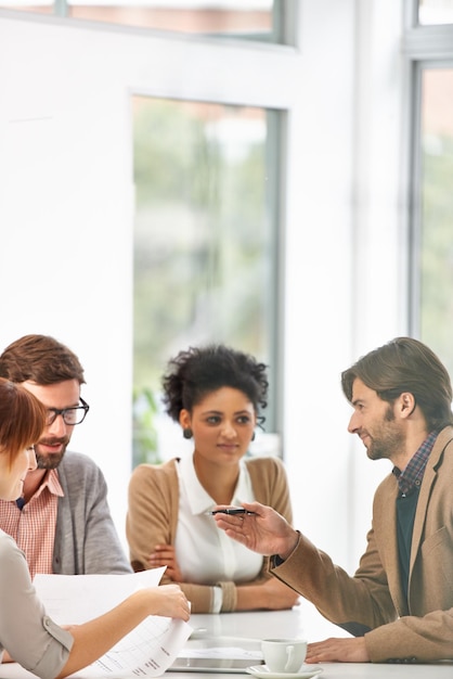 Bietet ein bisschen Geschäftsweisheit. Eine Gruppe von Geschäftsleuten geht in einem Büro gemeinsam Pläne durch.