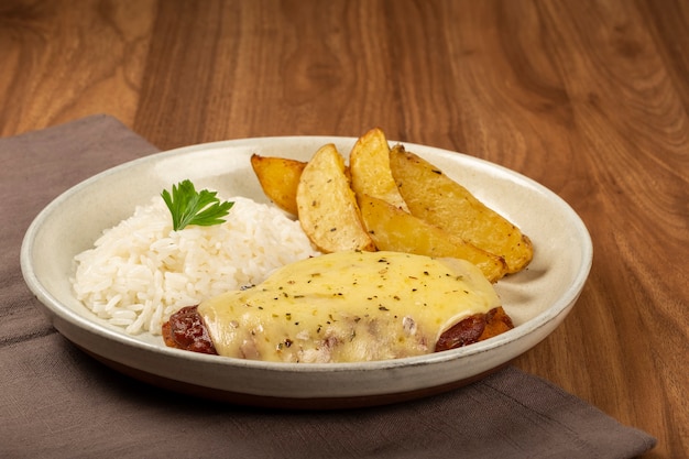 Foto bife à parmigiana com arroz e batata assada prato típico brasileiro