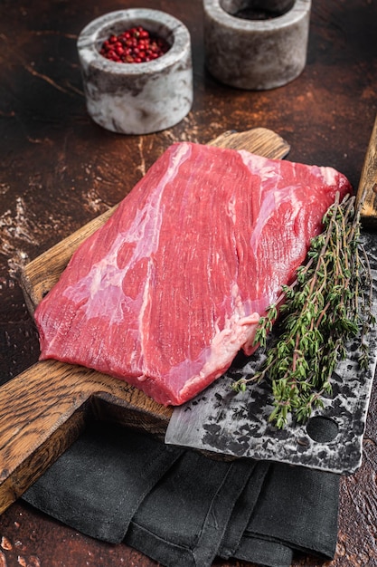 Bife alternativo de carne de flanco de aba crua na placa de açougueiro Fundo escuro Vista superior