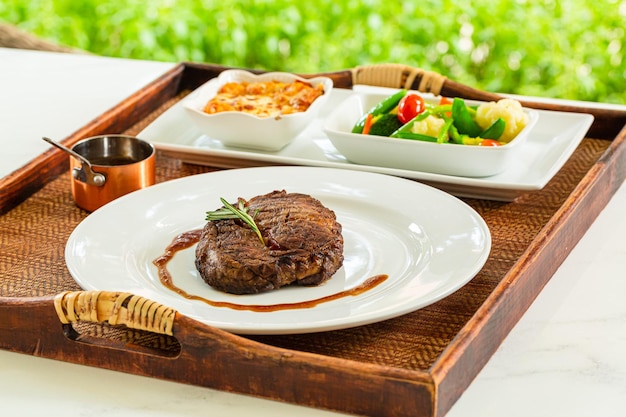 Bife, churrasco de estilo moderno, rosbife fatiado, envelhecido, com anéis de cebola fritos e purê de batata