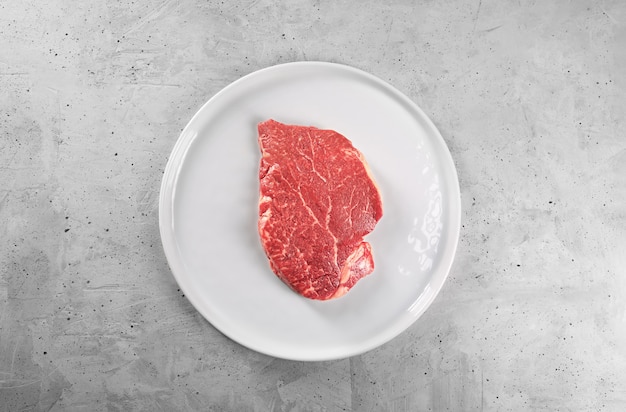 Bife com alecrim e pimenta em um prato branco com espaço de cópia