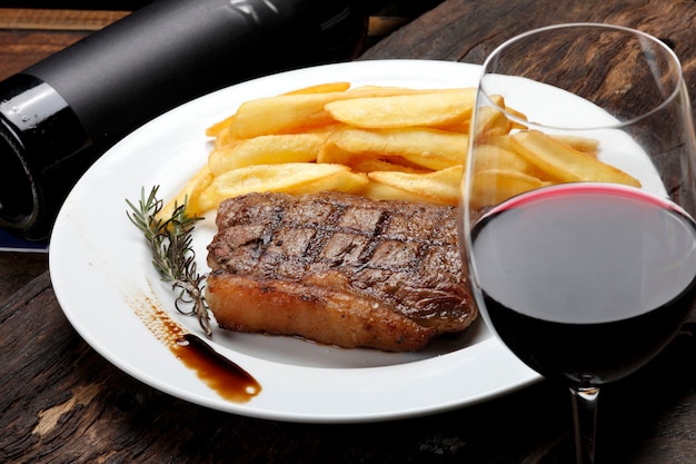 Bife com batata frita e vinho tinto