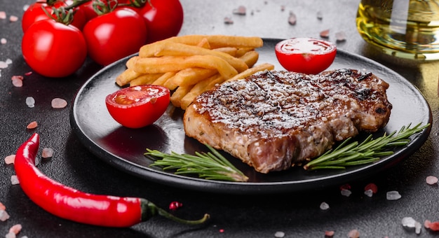 Bife com batatas, cebolas e tomates cereja. Bife suculento com manteiga aromatizada