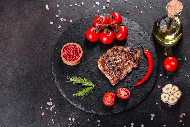 Bife com batatas, cebolas e tomates cereja. Bife suculento com manteiga aromatizada