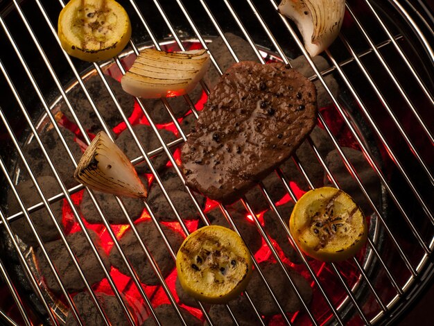 Bife com legumes cozinhando na grelha.