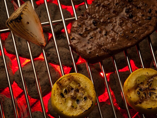 Bife com legumes cozinhando na grelha.